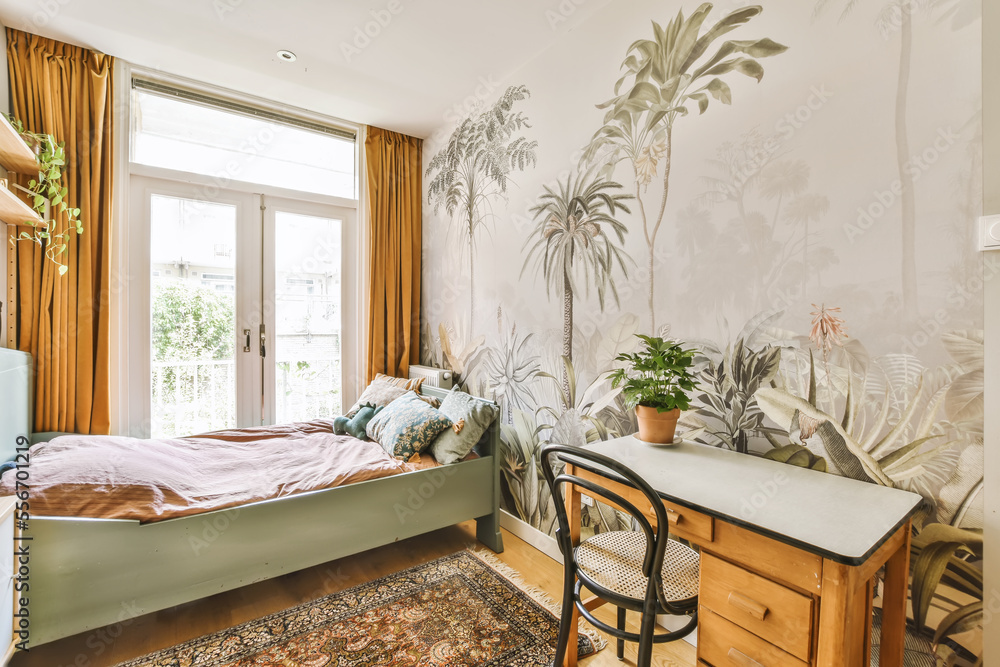 a bedroom with a bed desk and chair in front of a wallpapered