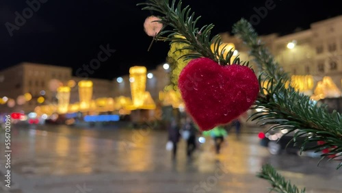 red heart on christmas tree with christmas market in background