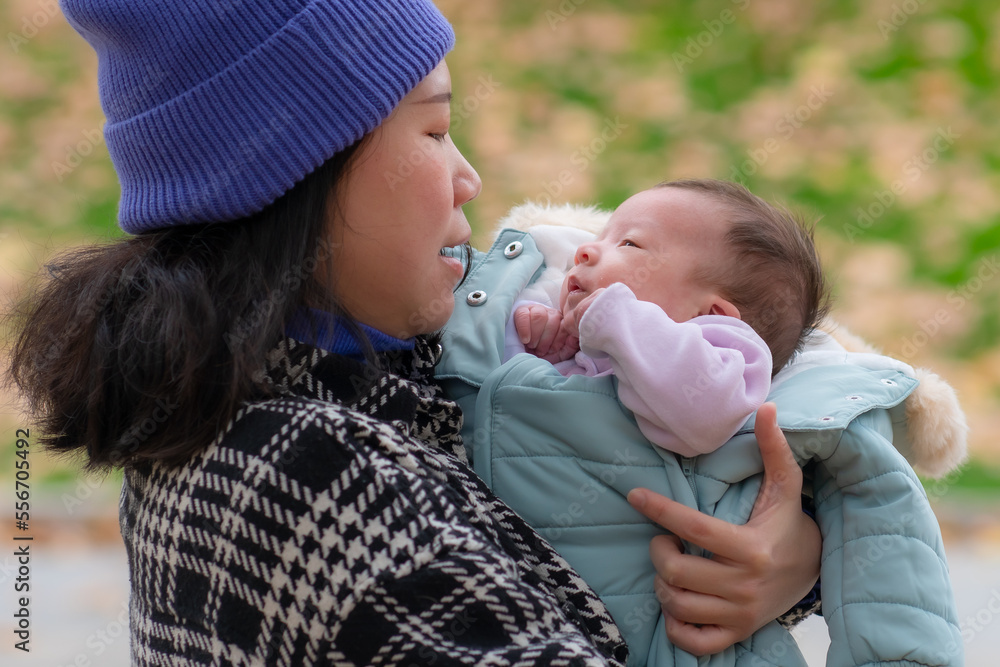 outdoors lifestyle portrait of young happy and beautiful Asian Chinese woman as mother of little adorable baby girl holding her tender and sweet in city park on sunny day outdoors lifestyle portrait of young happy and beautiful Asian Chinese woman as mother of little adorable baby girl holding her tender and sweet in city park on sunny day