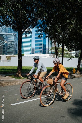A young couple riding their bikes together in the city.