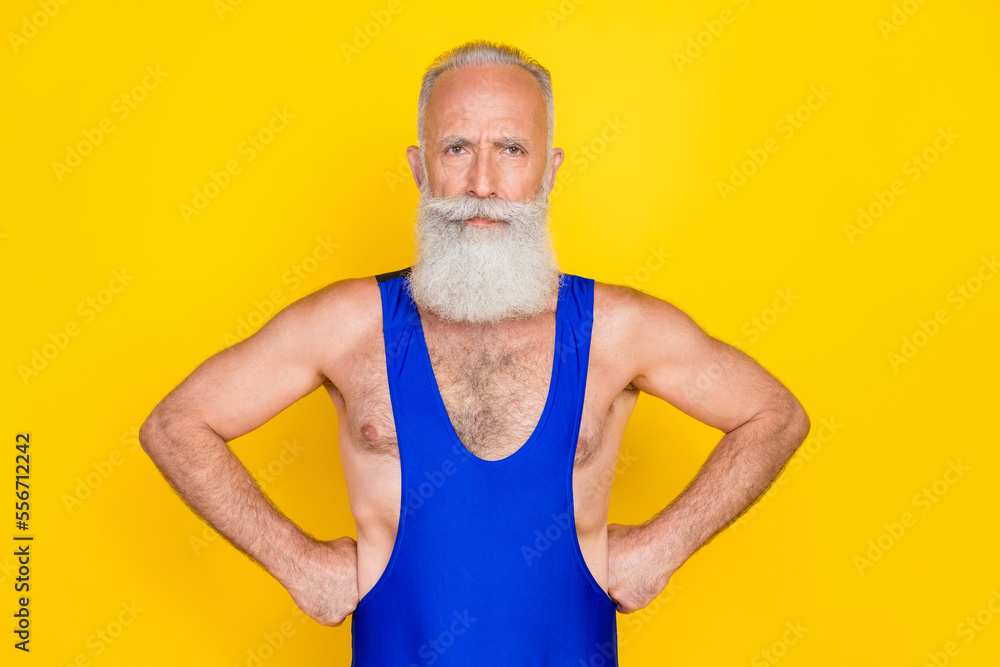 Photo of confident eccentric senior man hand touch waist training sport gym isolated on yellow color background Photo of confident eccentric senior man hand touch waist training sport gym isolated on yellow color background