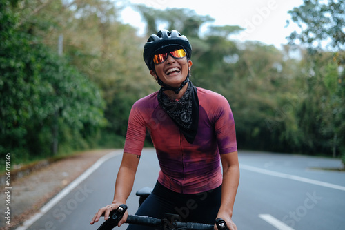 A young woman cyclist happily laughing.