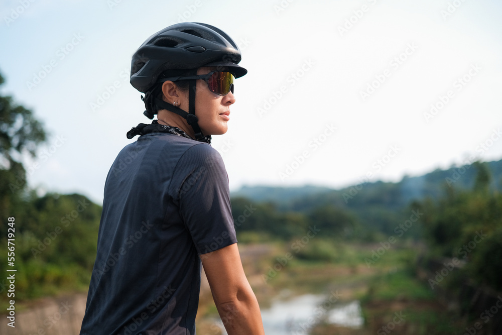 A young woman cyclist looking out on a view. A young woman cyclist looking out on a view.