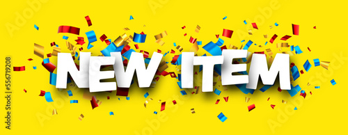 New item sign over colorful cut out foil ribbon confetti background.