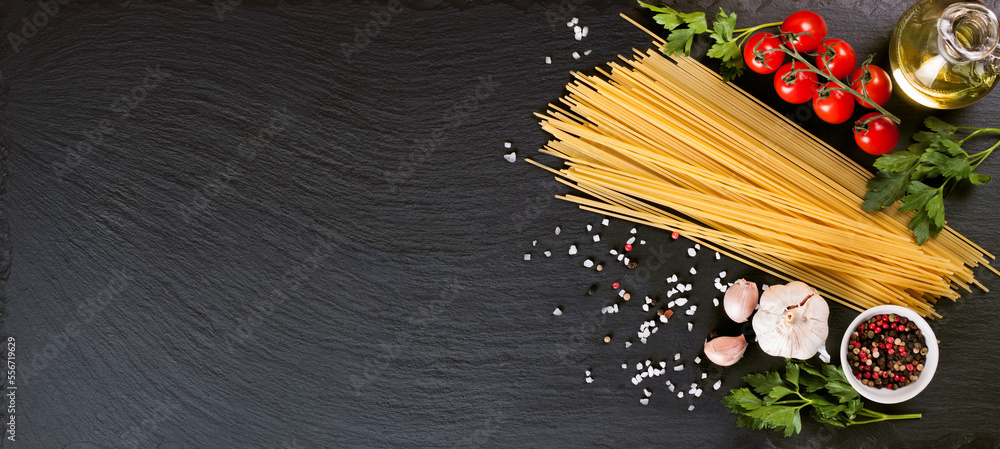 Pasta, spaghetti and cooking ingridients on black slate surface ...