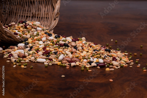 cesto di vimini con legumi e cereali su un tavolo di legno