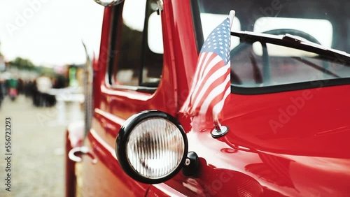Close Side View Of Red Pickup Truck With Small American Flag Waving.