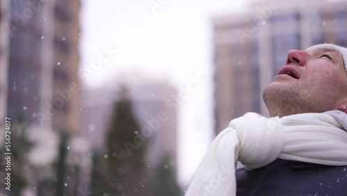 Freezed Caucasian sportsman standing on snowy day outdoors rubbing hands and leaving. Portrait of handsome adult man training outdoors in winter