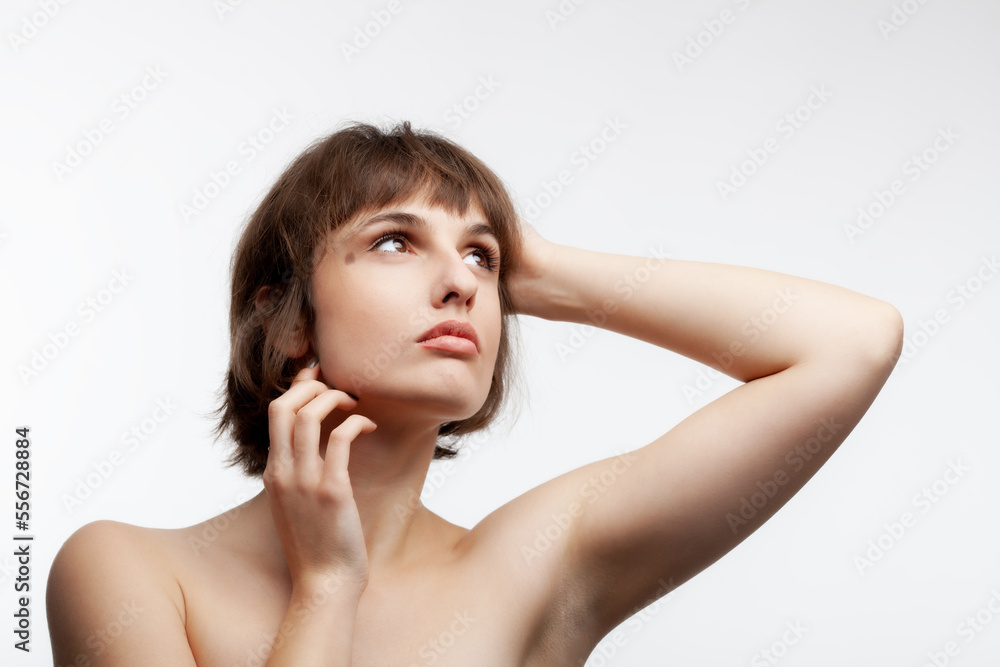 studio portrait of a beautiful brunette girl with short hair looking up isolated on white background. studio portrait of a beautiful brunette girl with short hair looking up isolated on white background.