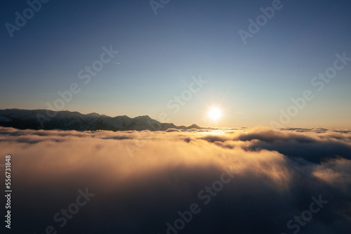 Caucasian mountains above the clouds at the sunset. Cloudscape  aerial view