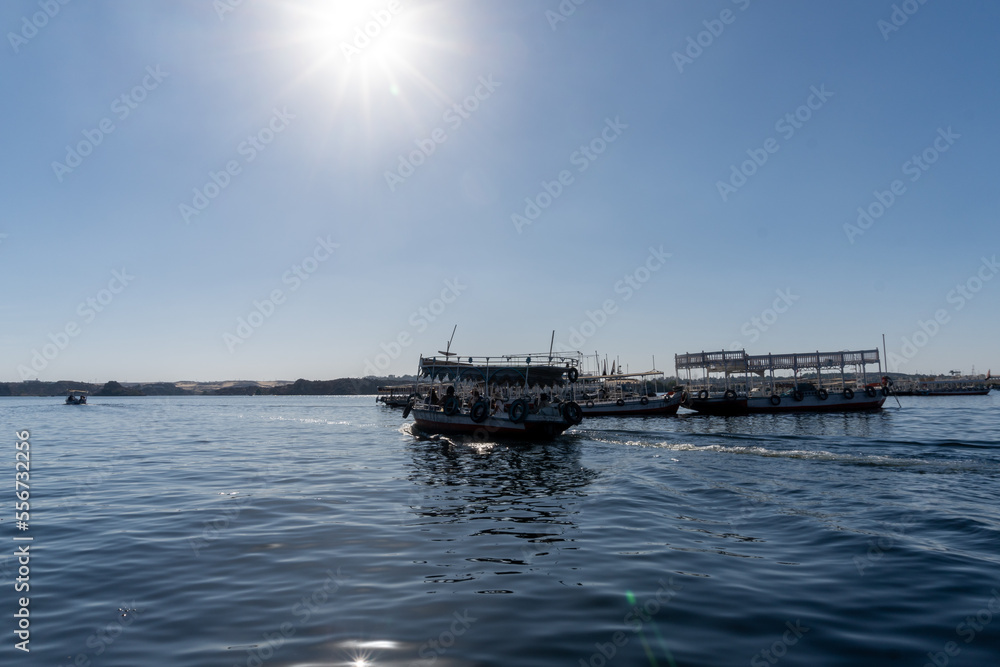 River Nile full of boats that take tourists to the Philae temple in the city of Aswan, on a sunny day.