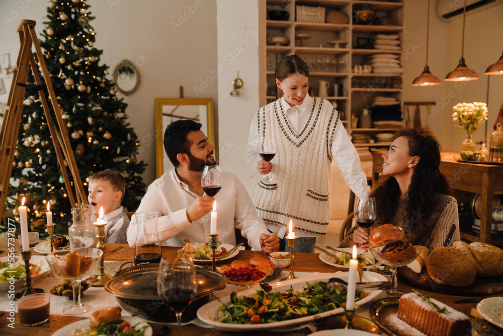 Happy family drinking wine while spending time together during Christmas dinner Happy family drinking wine while spending time together during Christmas dinner