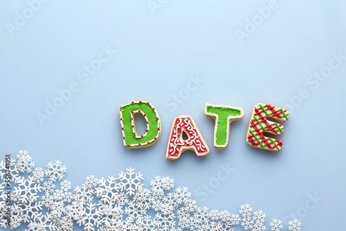 Overhead View of Letter Cookies spelling DATE on Blue Background with Snowflakes photo