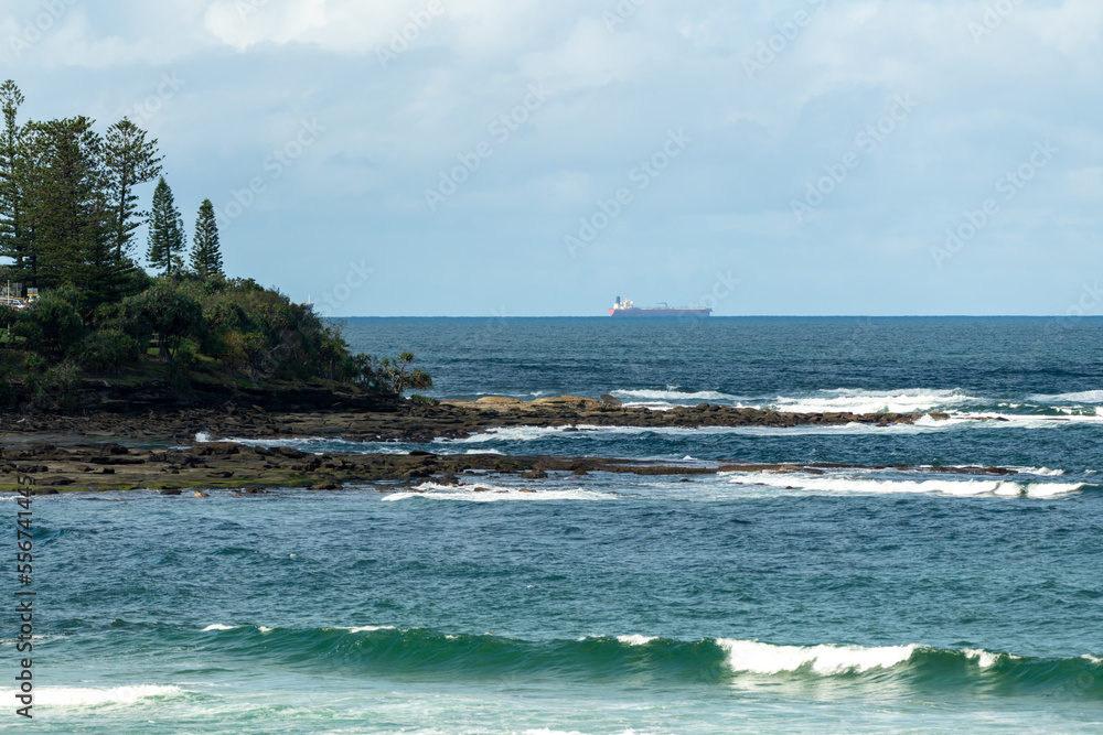 Stunning coastline of the Sunshine Coast in Queensland, Australia with ocean waves crashing into rock cliff face. 