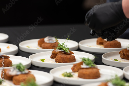 chief serving herring with potato Kroket croquette Dutchs favourite snack deep-fried ragout filled snack coated with breadcrumbs