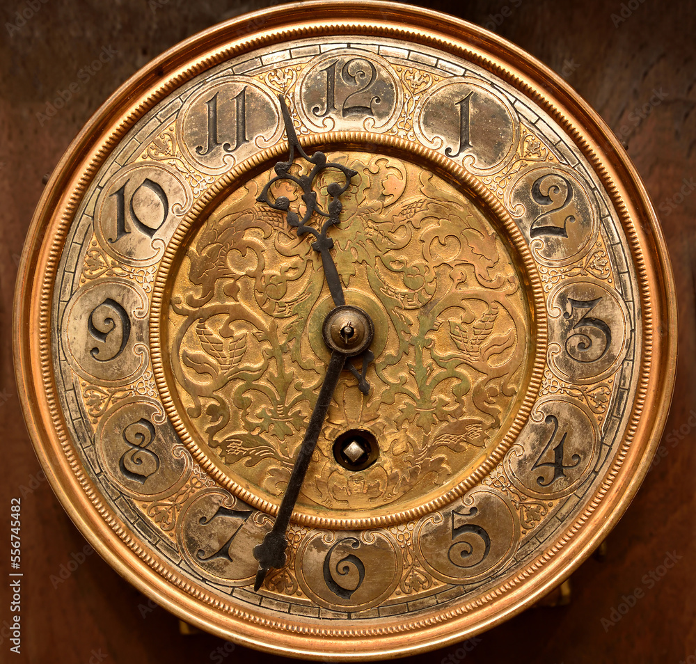 Very old and worn out gilded clock face. Close-up.
