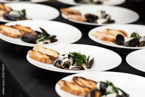 chief serving mussels in white wine sauce and white bread toasts