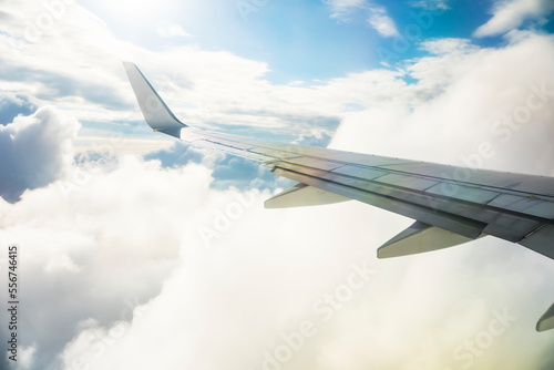 Airplane wing in sunlit clouds during travel down the coastline of Australia; Cairns, Australia photo