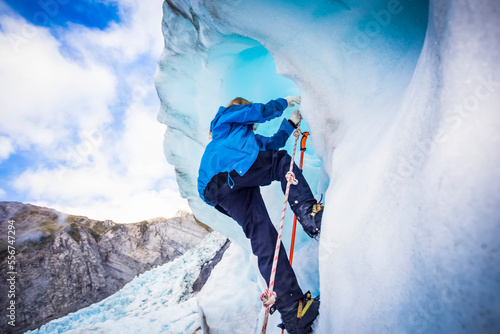 Travellers explore New Zealand's famous Franz Josef Glacier. Blue Ice, deep crevasses, caves and tunnels mark the ever changing ice; West Coast, New Zealand photo