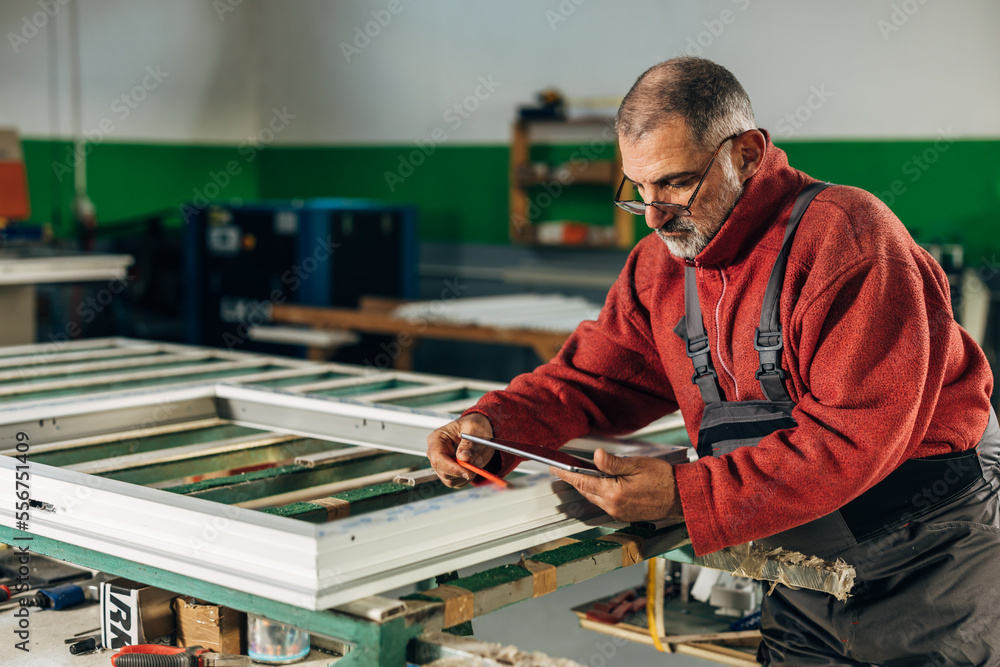 Mature handyman is doing final checks of the window frame Mature handyman is doing final checks of the window frame