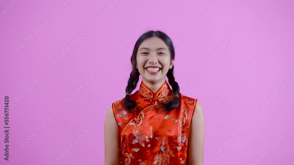 4K, portrait, Asian girl with braids wearing red Chinese national costume (cheongsam dress), She is laughing happily on Chinese New Year, Isolated indoor studio on blue background. 4K, portrait, Asian girl with braids wearing red Chinese national costume (cheongsam dress), She is laughing happily on Chinese New Year, Isolated indoor studio on blue background.