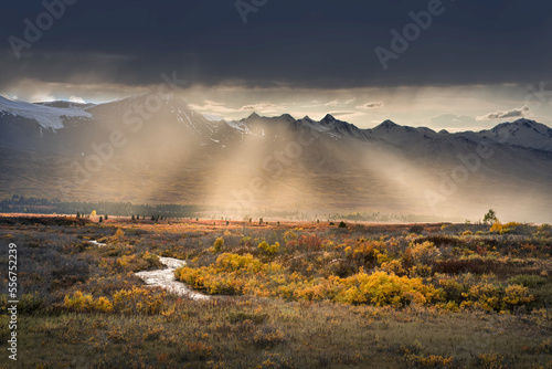 Coast Mountain Range with rays of sunlight beaming across the autumn tundra, Alaska, USA