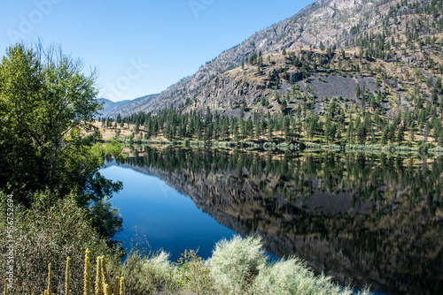 Mountain scene reflected on the pristine Blue Lake in Eastern Washington at the Sinlahekin Wildlife Area near Tonasket; Tonasket, Okanogan County, Washington, United States of America