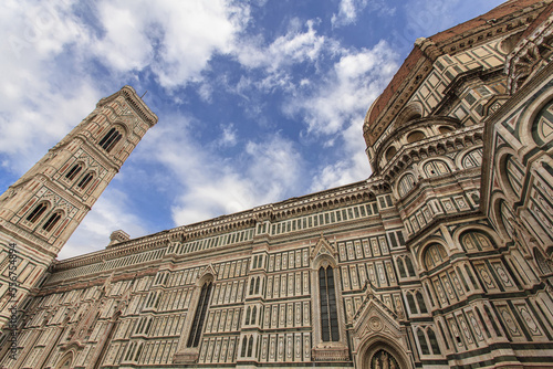 The famous Il Duomo di Firenze (Florence Cathedral) a highly decorated Gothic structure in green, white and pink marble against a cloudy blue sky; Florence, Tuscany, Italy photo