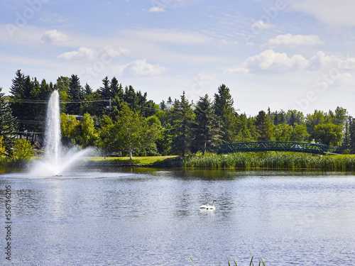 Fountain and footbridge on Mirror Lake in the community of Camrose; Camrose, Alberta, Canada