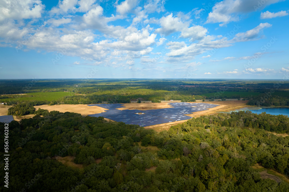 Obraz premium Aerial view of big sustainable electric power plant with many rows of solar photovoltaic panels for producing clean electrical energy. Renewable electricity with zero emission concept