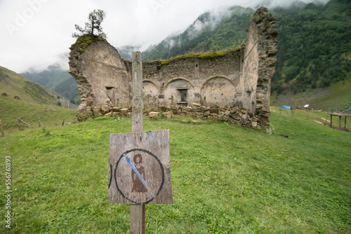 A wooden sign states no women allowed at the ruins of an old church in the village of Dartlo, Tusheti, Georgia; Dartlo, Kakheti, Georgia