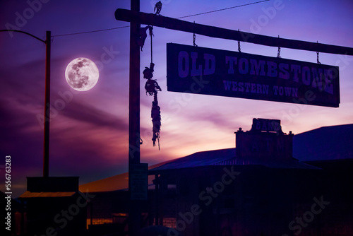 Silhouette of a skeleton hanging from the famed, western town of Tombstone with a full moon in a moody, purple sky; Tombstone, Cochise County, Arizona, United States of America photo