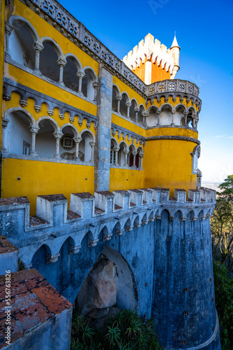 Painted, covered balconies and tower at the Palacio Da Pena with the crenelated fortified stone walls below; Sintra, Lisbon District, Portugal photo
