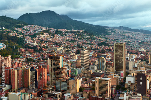 View of the center of the city of Bogota from the top of Torre Colpatria tower, Colombia. Cityscape with houses and mountains in the background under cloudy sky.