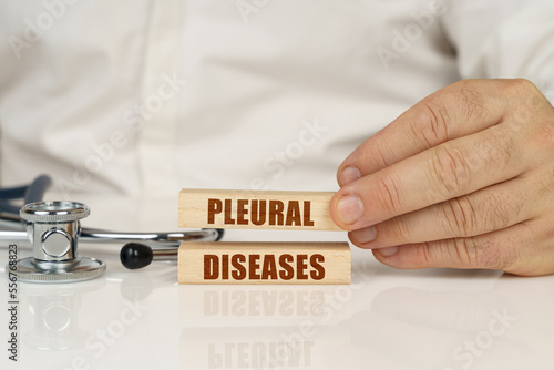 On a white surface, a stethoscope and wooden plates with the inscription - PLEURAL DISEASES photo