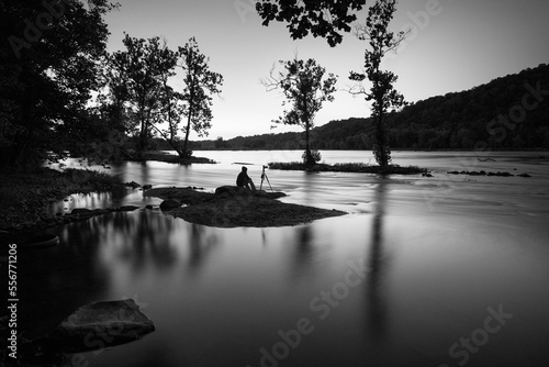 A photographer sits on an island at night and photographs nature.