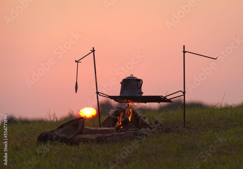 Tea kettle on a fire at sunrise.