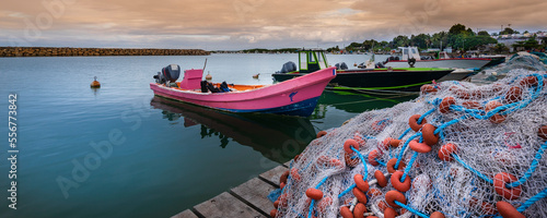 Motorboats and fishing boats moored to the dock, piled with fishing nets in the harbor in Sainte Rose on Basse-Terre; Guadeloupe, French West Indies photo