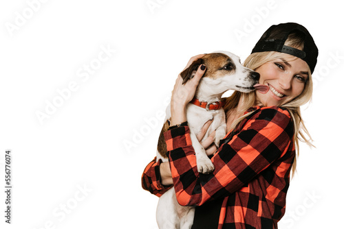 Tela Adorable blonde in baseball cap and checked shirt , broad smiling, hugs her puppy Jack Russel, who is licks her cheek, over transparent background