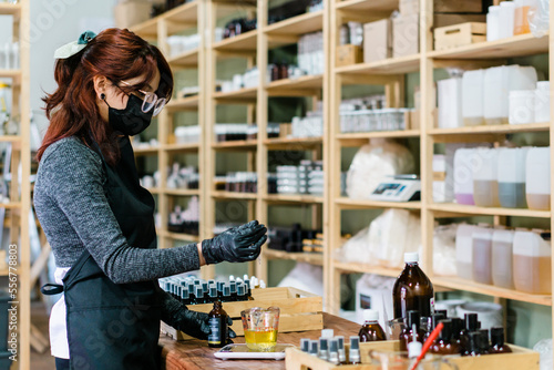 Woman in a laboratory preparing handmade essences. Real people.