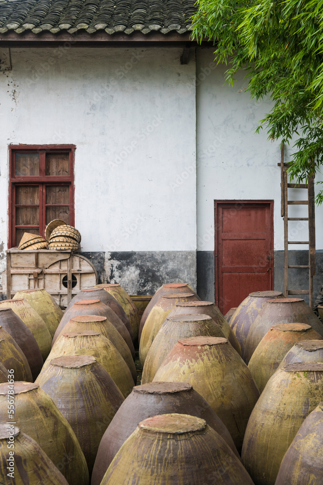 Traditional clay pots for making soy sauce by an old building at a soy sauce factory, Sichuan, China Traditional clay pots for making soy sauce by an old building at a soy sauce factory, Sichuan, China