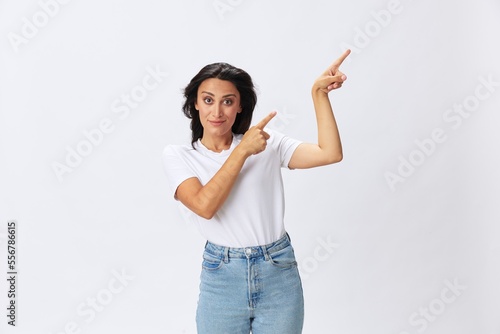 Woman smile and happiness shows a finger on the background, hand gestures, in a white t-shirt on a white background, copy space