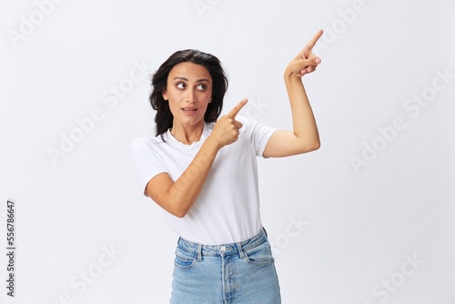 Woman smile and happiness shows a finger on the background, hand gestures, in a white t-shirt on a white background, copy space