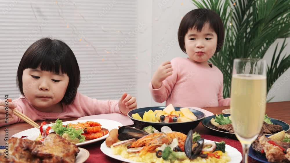 テーブルに並べられたクリスマスの料理を食べる子供