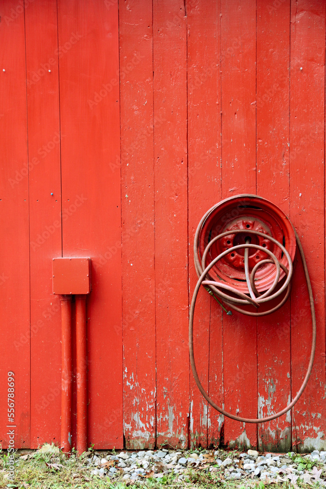 old red barn door with air hose 