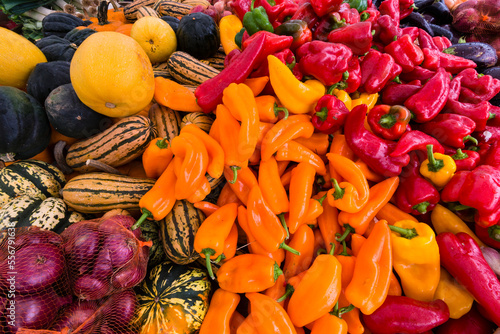 Fresh organic autumn vegetables on display for sale at a street market - pumpkins, red, orange and purple peppers, onions, eggplant; Sutton, Quebec, Canada photo
