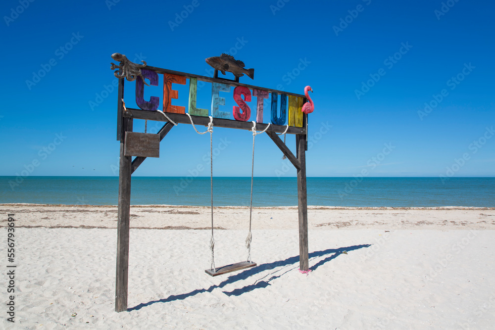 Swing with Celestun sign on a white sand beach on the coast of the Gulf of Mexico; Celestun, Yucatan State, Mexico Swing with Celestun sign on a white sand beach on the coast of the Gulf of Mexico; Celestun, Yucatan State, Mexico