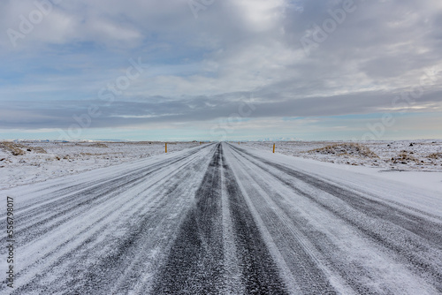 Strada rettilinea ricoperta di neve appena dopo una leggera nevicata con cielo nuvoloso photo