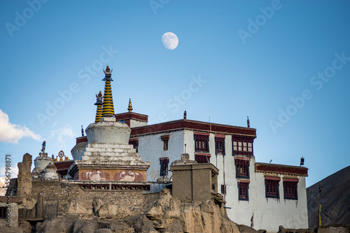 Closer view of the Tibetan Buddhist Lamayuru Monastery on a clifftop at sunset in Lamayouro of the Leh District in the Ladakh Region, with the moon appearing in the blue sky; Jammu and Kashmir, India photo