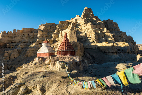 Ruins of the Guge Kingdom with prayer flags in the mountainous landscape of the Sutlej Valley in the Himalayan Mountains; Tsaparang, Zanda, Tibetan Autonomous Region, Tibet photo